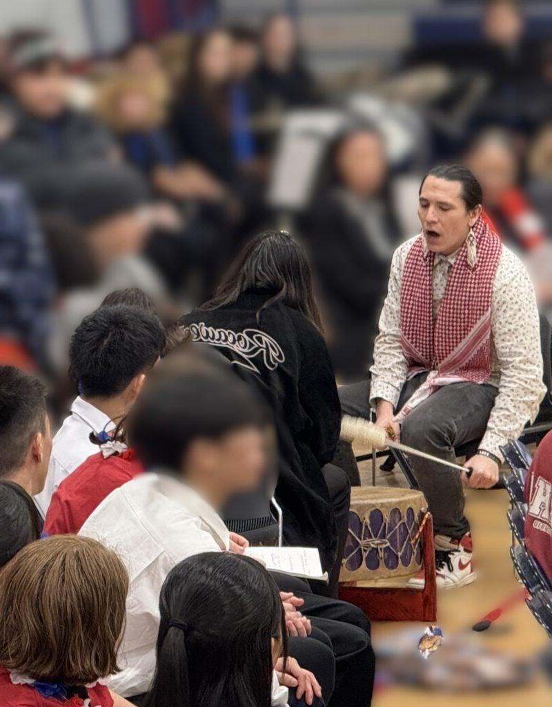 Photo of Native man drumming and singing